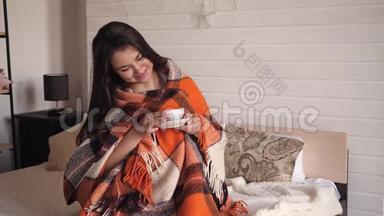 一个冬天的晚上，孕妇在家喝茶，在温暖舒适的格子下喝茶。